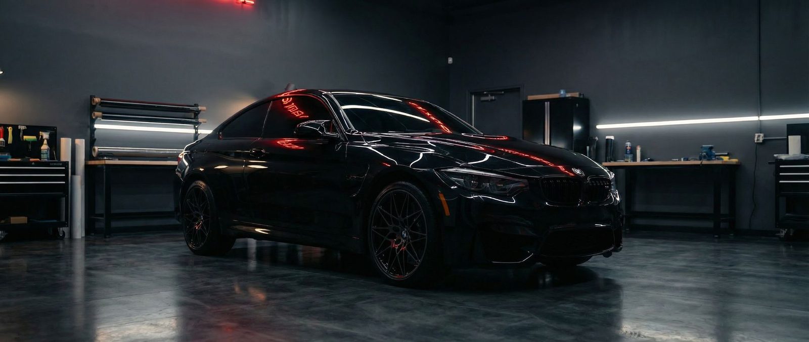 Black luxury car with premium window tint in professional tint shop